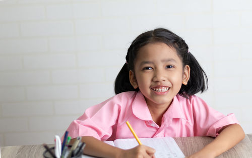 Portrait of cute girl writing in book