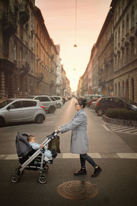 Woman pushing stroller on street