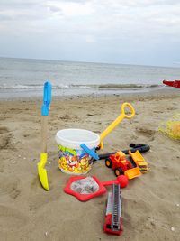 Toys on beach against sky