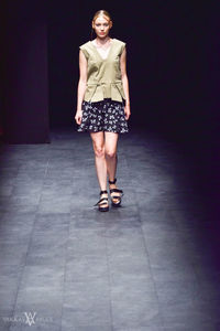 Full length portrait of woman standing on tiled floor