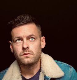 Portrait of man against black background