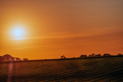 Scenic view of field against sky during sunset