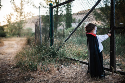 Rear view of man standing by fence