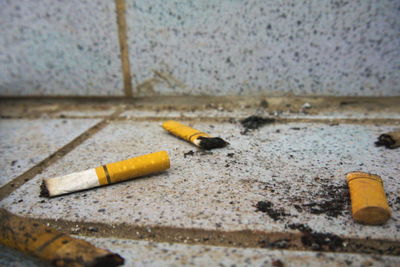 Close-up of cigarette butts on footpath