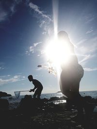 Side view of silhouette man at beach against sky