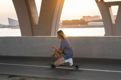 Woman sitting on bridge over water