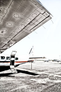 Airplane flying over airport runway against sky