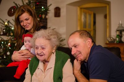 Portrait of friends with christmas tree at home