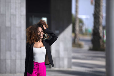 Portrait of young woman standing in city