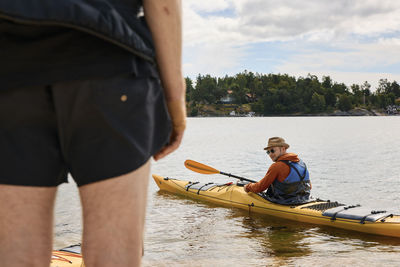 View of man sitting in kayak on water