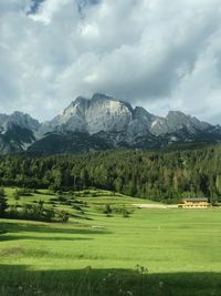 Scenic view of field and mountains against sky