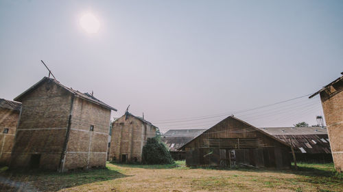 Houses on field against clear sky