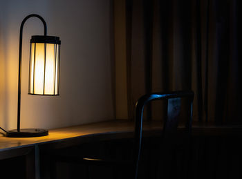 Electric lamp on table against wall at home