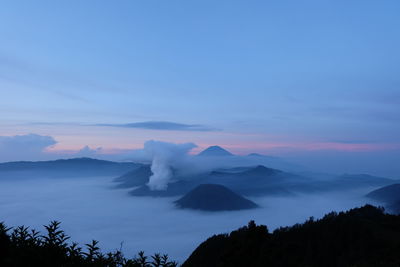 Scenic view of volcanic mountain against sky during sunset