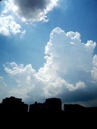 Low angle view of buildings against cloudy sky