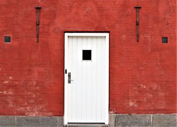 Closed white door of red building