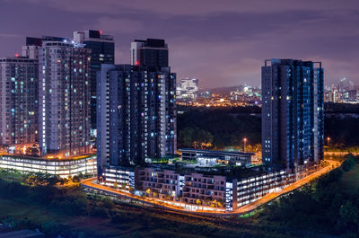 High angle view of illuminated buildings against sky at night