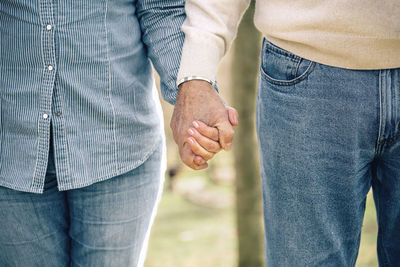 Midsection of couple holding hands