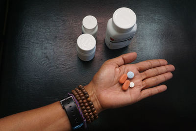 Cropped hand of woman holding pills