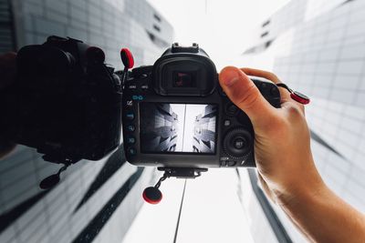 Cropped hand of man photographing with camera