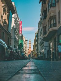 Street amidst buildings against sky in city