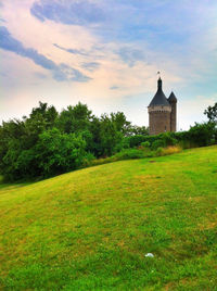 Scenic view of grassy field against cloudy sky