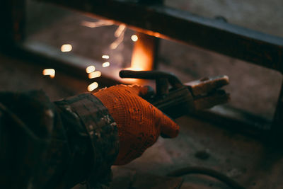 Cropped hand of worker holding equipment at factory