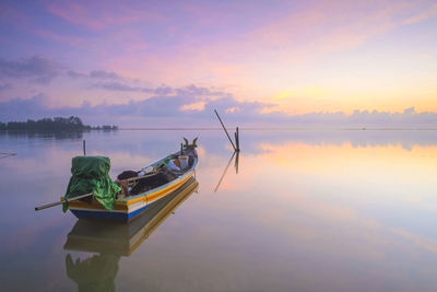 Ship moored on sea against sky during sunset