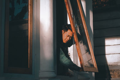 Man looking through window