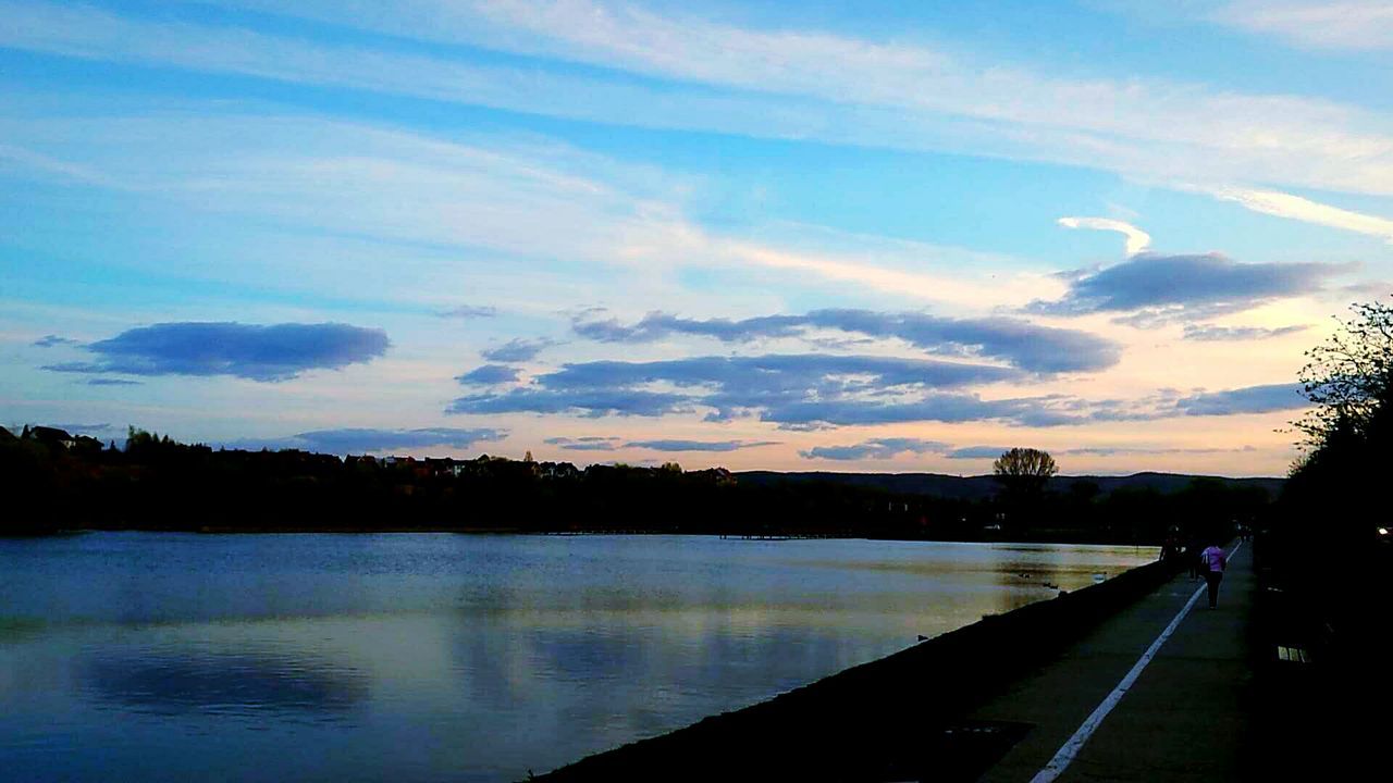 sky, water, transportation, the way forward, sunset, road, cloud - sky, silhouette, river, tranquility, tree, tranquil scene, cloud, nature, scenics, diminishing perspective, beauty in nature, railing, vanishing point, street