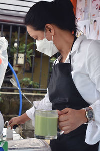 Side view of young woman drinking glass