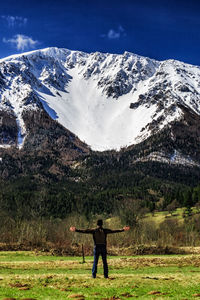 Full length of man standing on snowcapped mountain