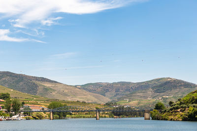 Scenic view of river by mountains against sky