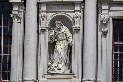 Low angle view of statue against historic building