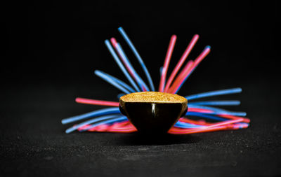 Close-up of multi colored pencils on table against black background