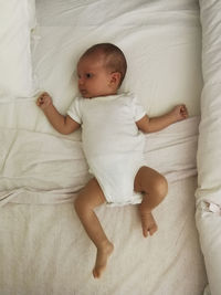 High angle view of baby lying on bed at home