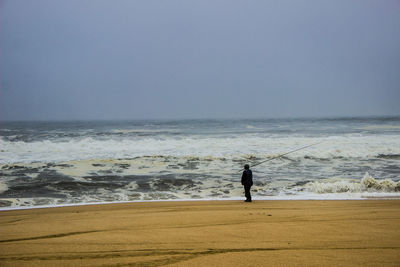 Full length of man on beach against clear sky