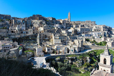 Buildings in city against blue sky