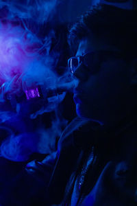 Portrait of man smoking cigarette at night