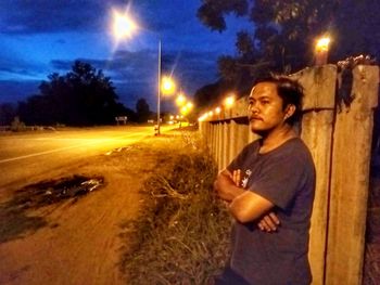 Side view of man standing on road at night