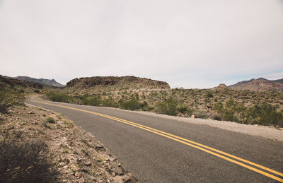 Road by mountain against clear sky