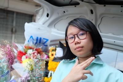 Close-up portrait of young woman gesturing in car trunk