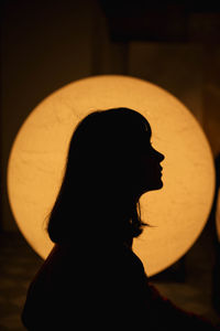 Side view of silhouette woman against sun