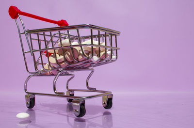 Close-up of pink metal on table against wall