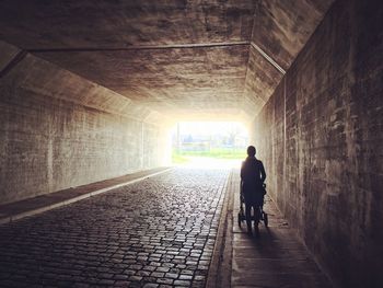 Rear view of silhouette man walking in tunnel