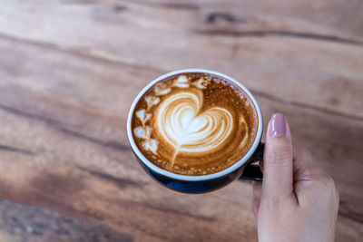 Cropped image of hand holding coffee cup