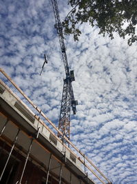 Low angle view of crane against sky