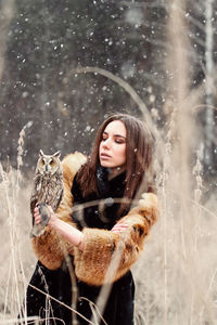 Young woman holding owl