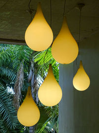 Close-up of illuminated lighting equipment hanging against wall