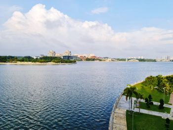 Scenic view of river by buildings against sky